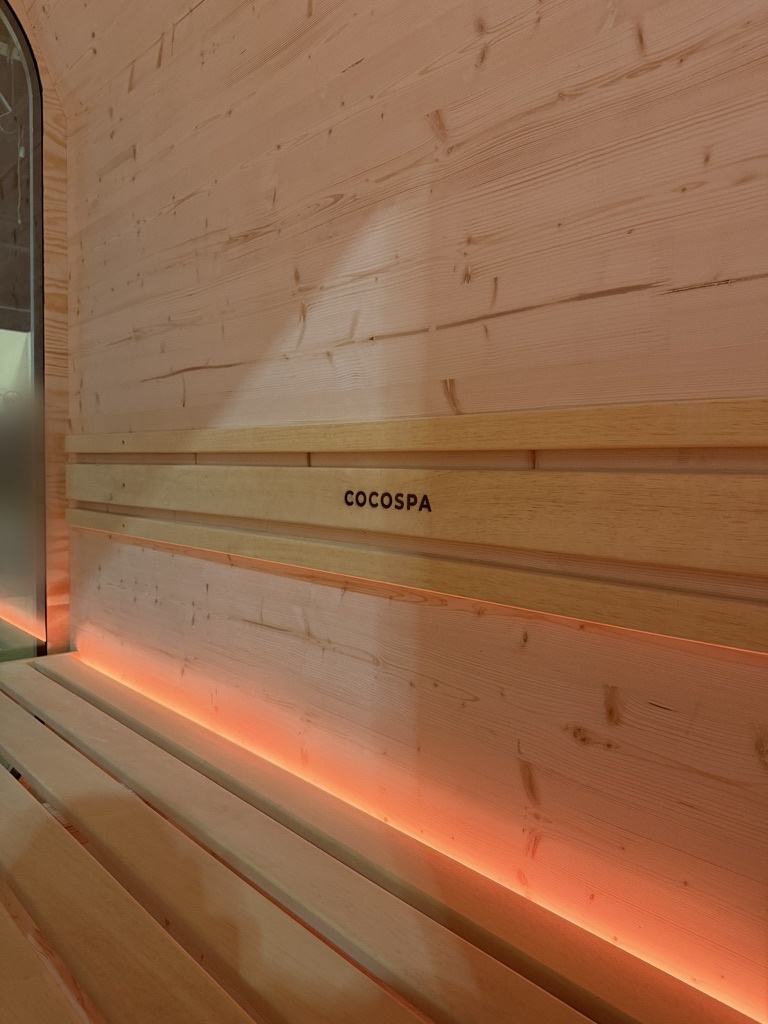 Detal ściany sauny COCOSPA Oslo 220 z logo COCOMODULE i podświetleniem LED